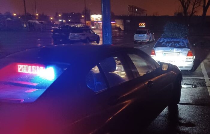 Kontrola policyjna samochodu marki BMW na parkingu przy ul. Orkana