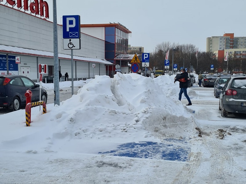 Śnieg z parkingu przed marketem Auchan spychany jest na miejsca postojowe dla niepełnosprawnych | fot. czytelnik Robert