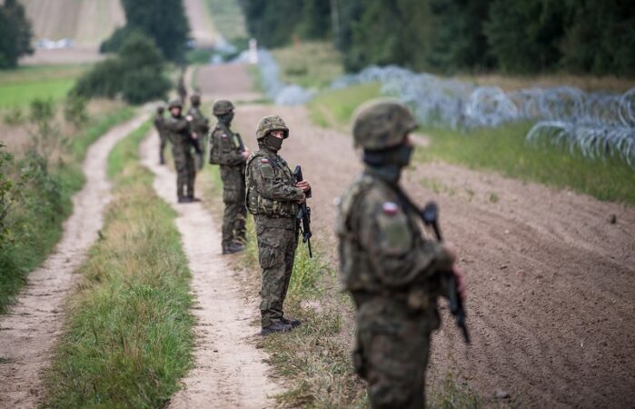 Żołnierze pilnujący płotu na granicy polsko-białoruskiej