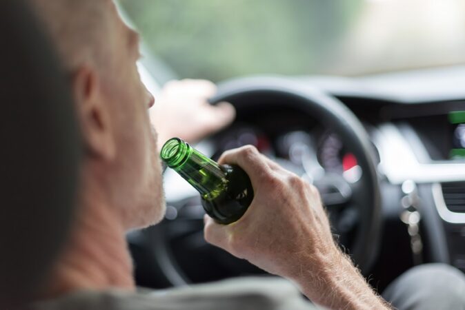 Mężczyzna pijący piwo podczas jazdy