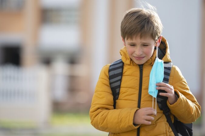 uczeń ściągający maseczkę po wyjściu ze szkoły