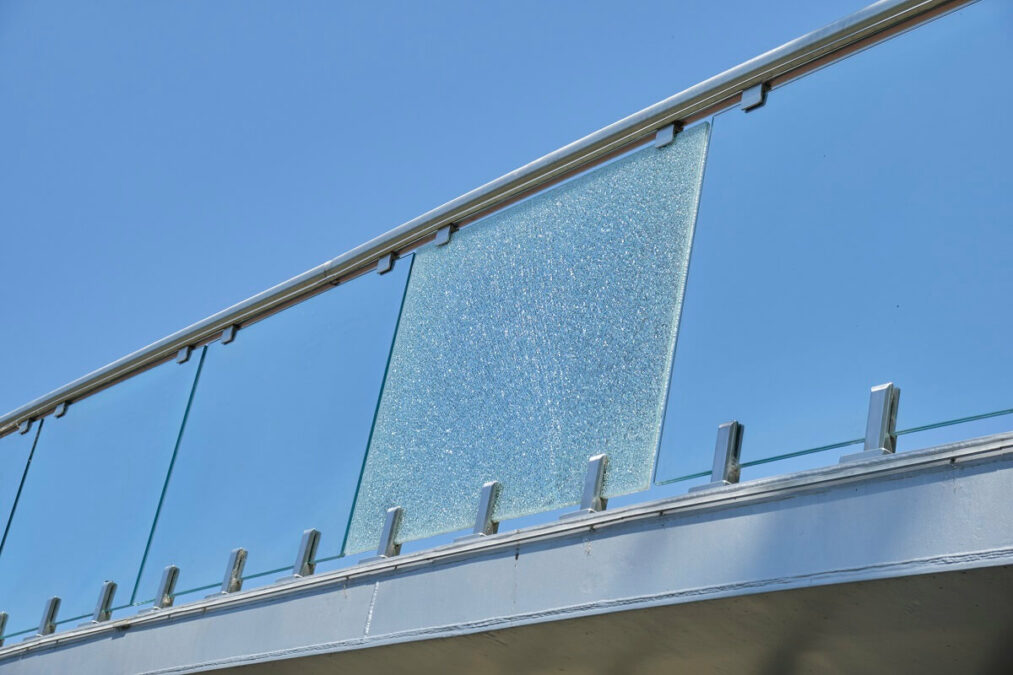 Pęknięta szklana płyta balustrady kładki przy Parku Ludowym