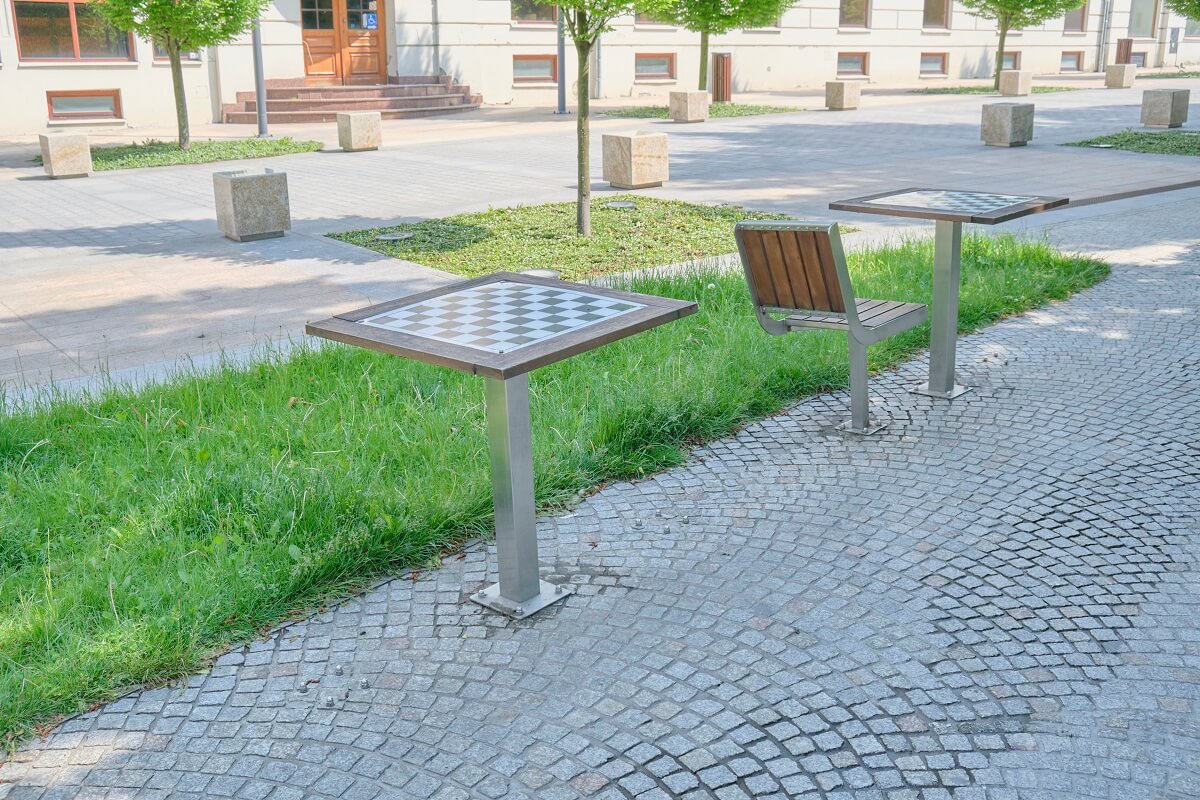 Zniszczone krzesła i stoliki do gry w szachy na placu Litewskim