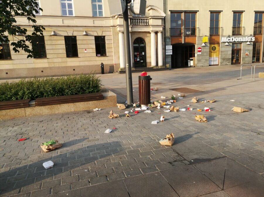 Porozrzucane śmieci przy koszu na placu Litewskim