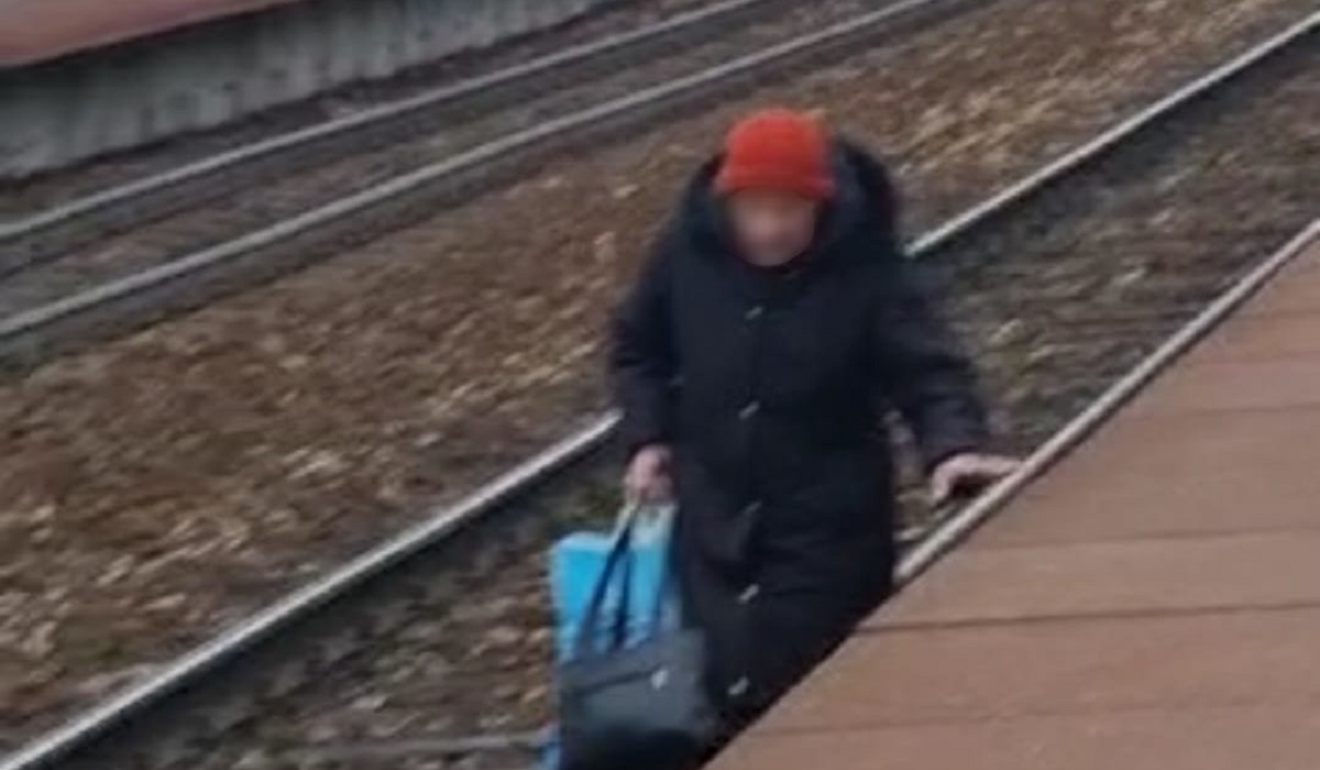 Staruszka idąca torami w kierunku nadjeżdżającego pociągu