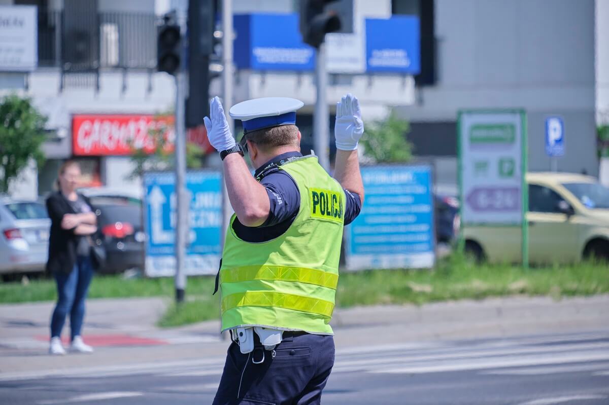 Policjant kierujący ruchem na skrzyżowaniu z wyłączoną sygnalizacją świetlną