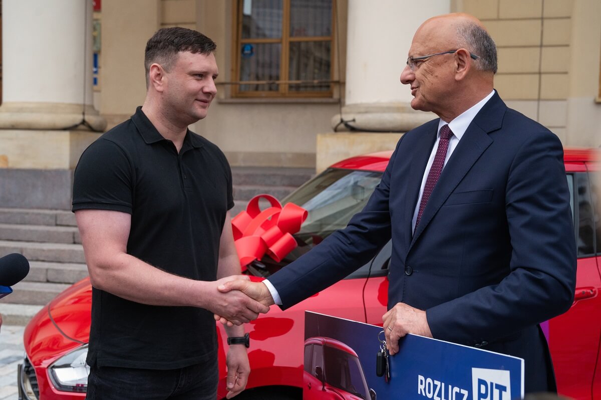 Prezydent miasta Lublin Krzysztof Żuk przekazuje zwycięzcy loterii nagrodę główną