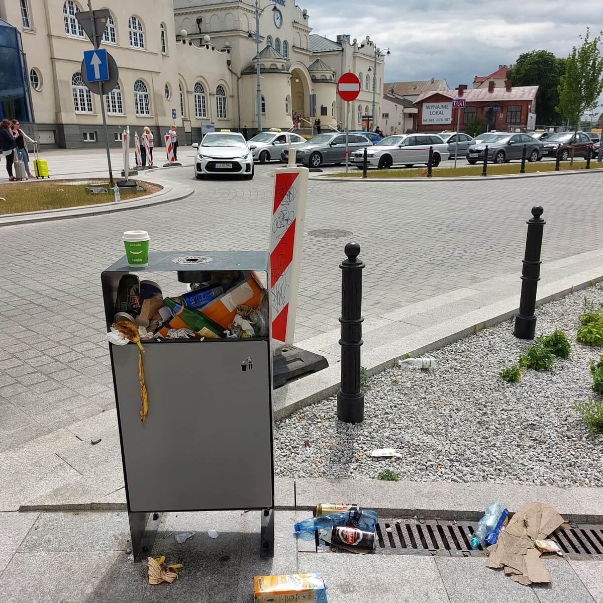 Przepełnione kosze i zalegające śmieci na ul. 1 Maja