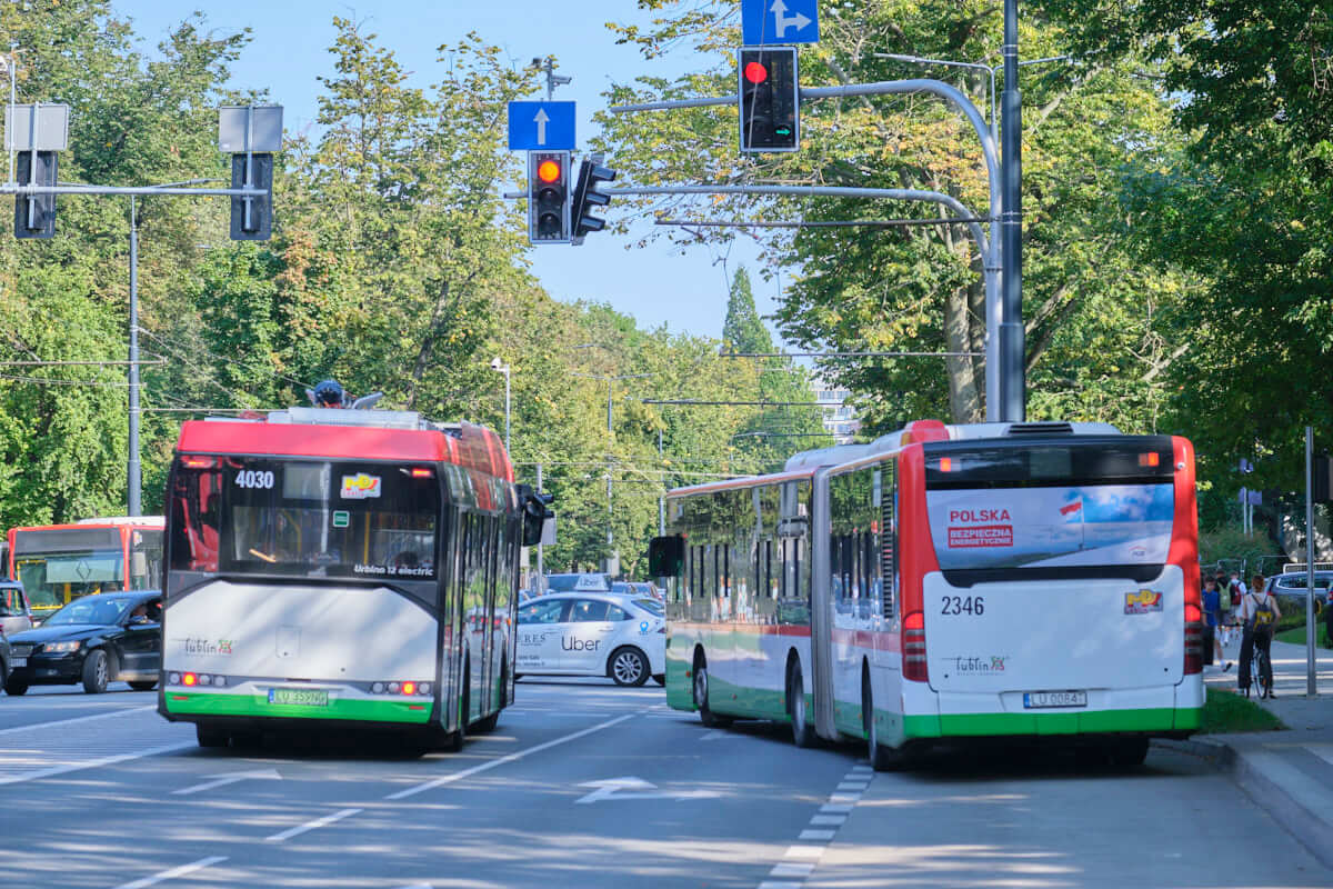 autobus elektryczny i autobus przegubowy przed skrzyżowaniem