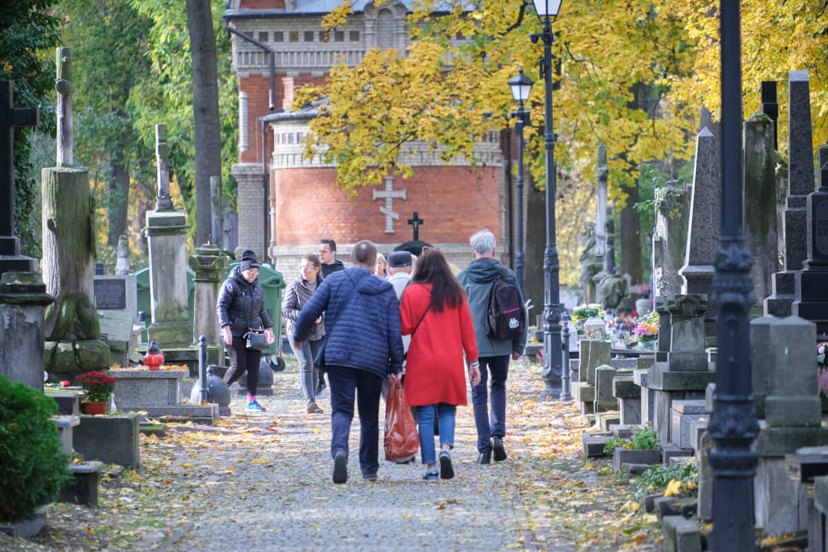 ludzie spacerujący po cmentarzu