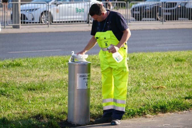 Pracownik MPWiK czyszczący poidełko wody pitnej