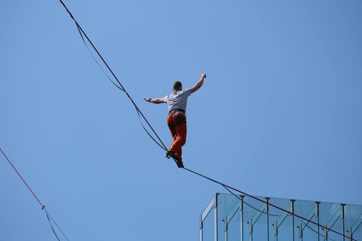 Slackliner chodzący pomiędzy budynkami Lubelskiego Centrum Konferencyjnego i Centrum Spotkania Kultur