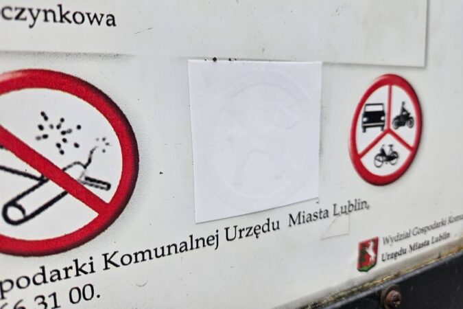 Zaklejony znak zakazu wyprowadzania psów na tablicy informacyjnej w Ogrodzie Saskim