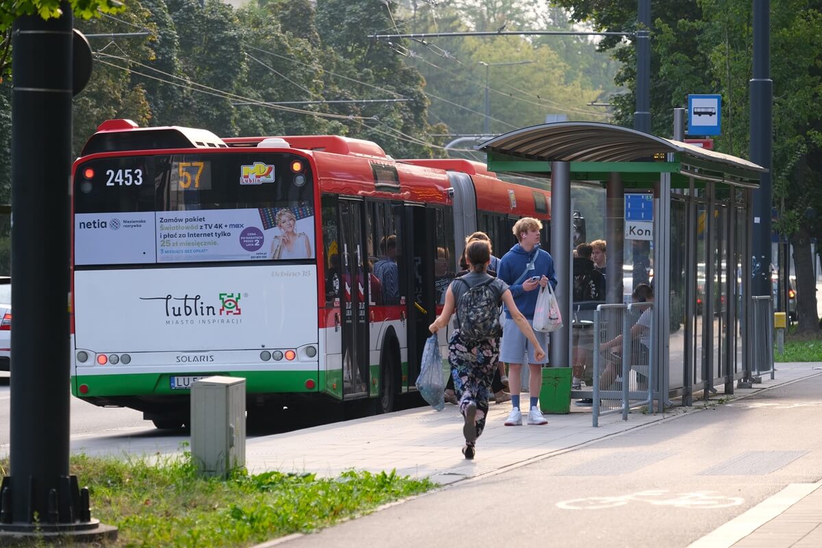 Kobieta biegnąca na autobus oczekujący na przystanku