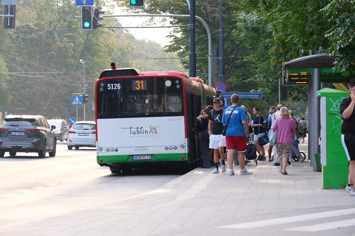 Pasażerowie siadający na przystanku to autobusu