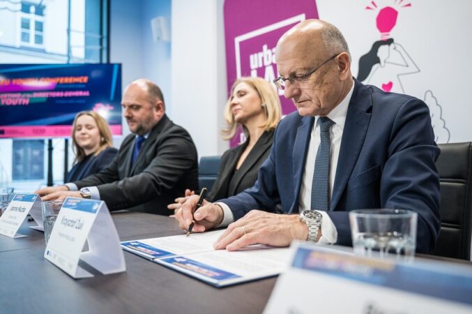 Krzysztof Żuk podpisujący dokument